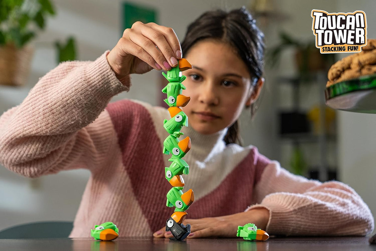 Child creating a tall tower with green Toucan Tower stacking figures