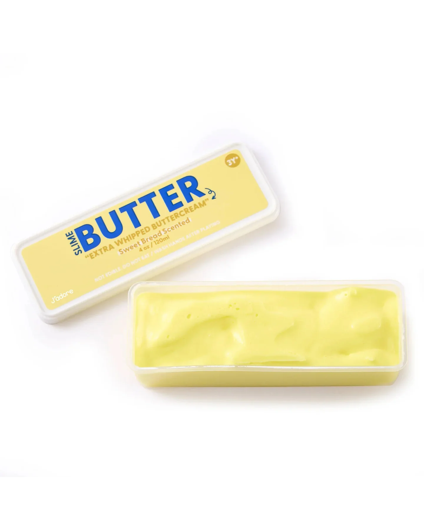A rectangular container of yellow Jadore Butter Slime labeled “Extra Whip,” with the lid placed next to it, revealing the smooth, creamy texture inside—perfect for sensory play or as a stress relief treat, much like the satisfying feel of buttercream.
